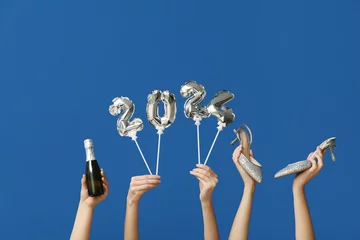 Poster Female hands with champagne bottle, high heel shoes and figure 2024 made of balloons on blue background © Pixel-Shot