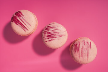 Colorful french macarons. French macarons on pink background, top view. Sweet macarons.