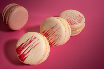 French macarons on pink background, top view. Sweet macarons. Colorful french macarons