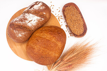Whole wheat breads, wheat ears and wheat grains on white background, top shot photo.