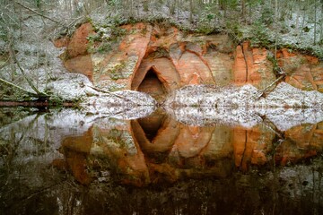 View to the Angels cave, a red sandstone cliff at the river Salaca in Skanaiskalns Nature Park in Mazsalaca in November in Latvia