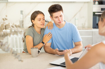 Fototapeta premium Married couple during conclusion of transaction, clients consult with manager about terms of cooperation, amount of payments on deposit