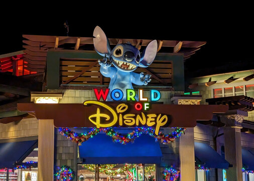 World of Disney store entrance sign with Stitch sign at night time
