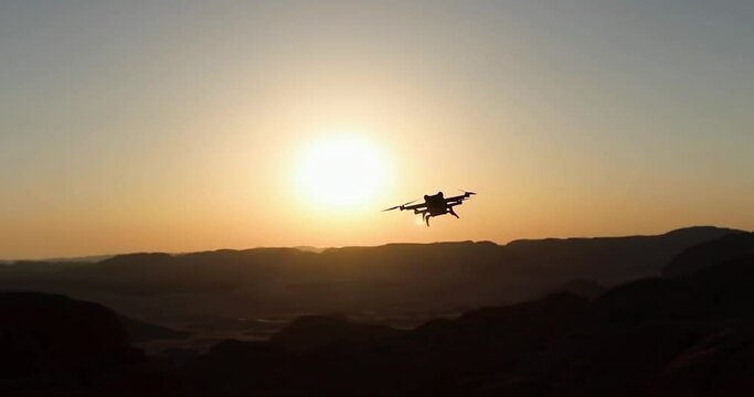 Drone flying against sunset sky