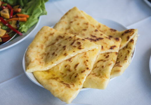Georgian food in restaurant - bread filled with cheese called Imeretian khachapuri