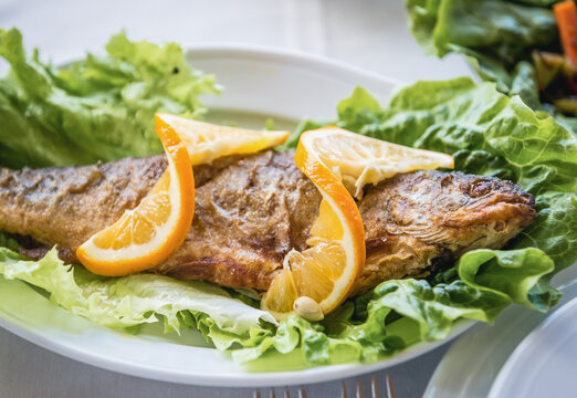 Georgian food in restaurant - roasted fish with lemon slices