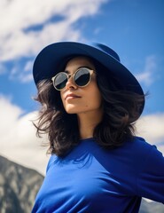 Fototapeta premium A woman wearing a blue hat and sunglasses. Generative AI.