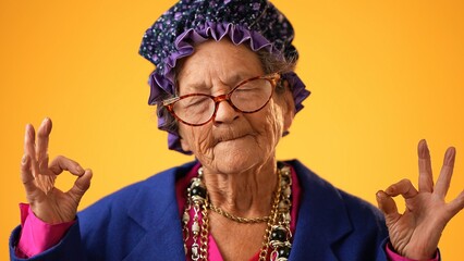 Closeup of funny crazy grandmother senior woman saying OM, 80s, meditating doing yoga exercise...