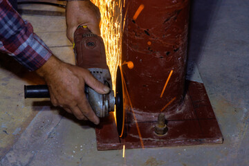 While grinding iron worker cuts metal with an using abrasive disk processing spark