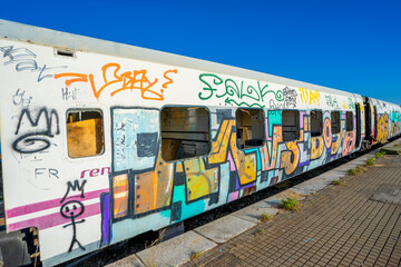 Vandalized train carriages with paintings without artistic expression, only with drawings with destructive intent, installed in the old railway station in the city of Barreiro. - obrazy, fototapety, plakaty