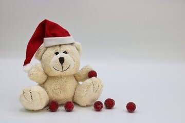 Christmas card with teddy bear with Christmas hat and red balls