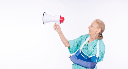 Injury elderly woman patient gown broken arm using loudspeaker scream copy space over isolated...