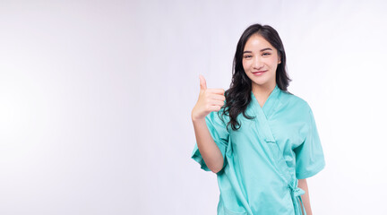 Cheerful patient asian woman showing thumb up smiling on white background. Diagnosis patient young girl checkup holding thumbs up good healthy over isolated. Insurance health care and accident concept