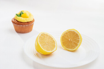 Lemon split with lemon cupcake, decorated with lemon buttercream with fondant figure on white background