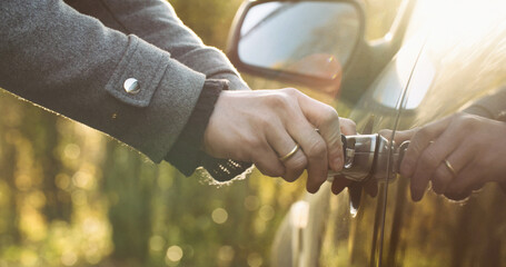 Woman unlocking a car door with a key. Travel and mobility concept - obrazy, fototapety, plakaty