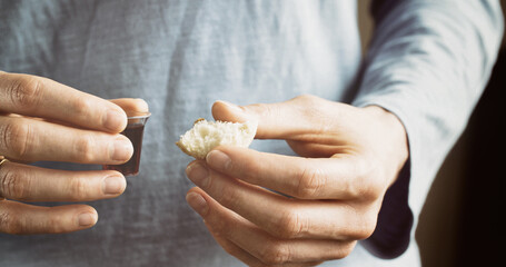 Woman taking communion - bread and wine. Christian faith and practice concept