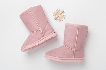 Beautiful childish ugg boots on color background,top view