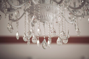 large round chandelier with crystals and candlesticks on the ceiling, retro style. Beautiful chandelier in luxury room shining. crystal chandeliers with lots of lights in a restaurant.