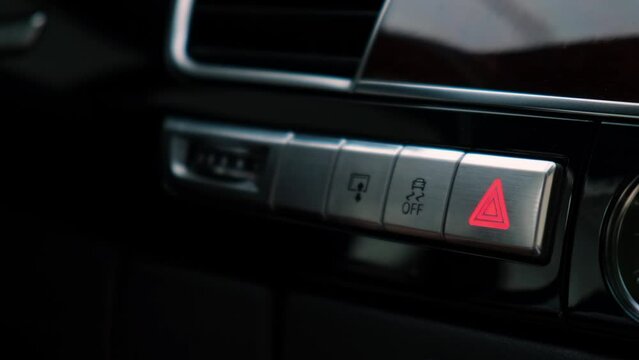 Red emergency button flashing Interior of modern luxury car. Details of automatic transmission gear shift, multimedia control system, car control panel, Air Vent and dashboard inside. Prestige sport