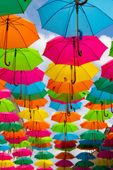 Multicolored umbrellas against a blue sky