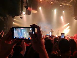 Spectators at the concert shoot a video of the concert with the concert hall scene at the show on...