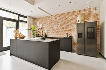 Modern kitchen with black countertop and brick wall