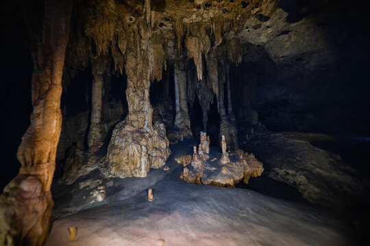 Majestic view of Cenote Dos Ojos in Mexico with towering stalactite formations in darkness