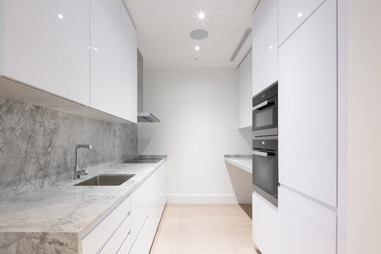 Modern Kitchen With Marble Counter And White Cabinets