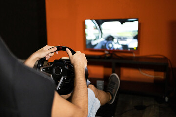 Man playing a racing game with steering wheel controller