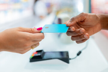 Anonymous hands holding credit card in drugstore