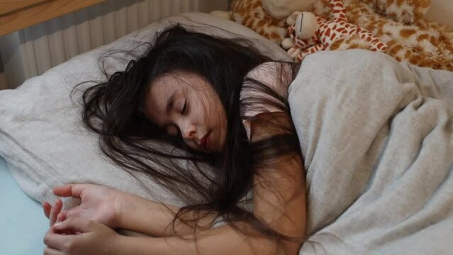 Sleeping brunette girl in bed.