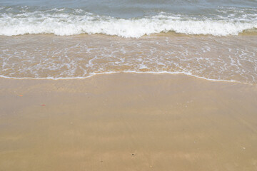  peaceful water and sand composition useful for background of sandy beach with water edge Gentle sea waves rolling onto sandy beach, soft surf, natural coastal landscape, travel background.