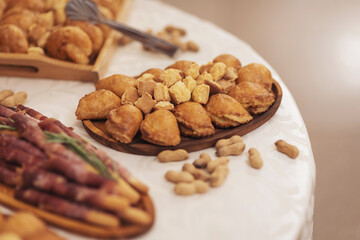 Snacks for the holiday, catering. Various snacks. Catering plate. Assortment of sandwiches on the buffet table. Prosciutto Crudo, Parma ham, meat, buns, nuts, cheese, of celebration of important event