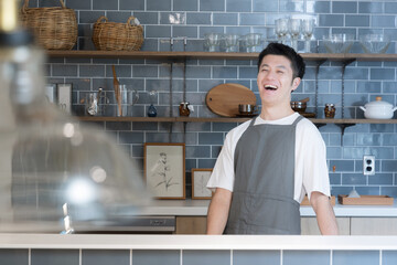 キッチンに笑顔で立つ男性　店舗の売上アップなどのイメージ