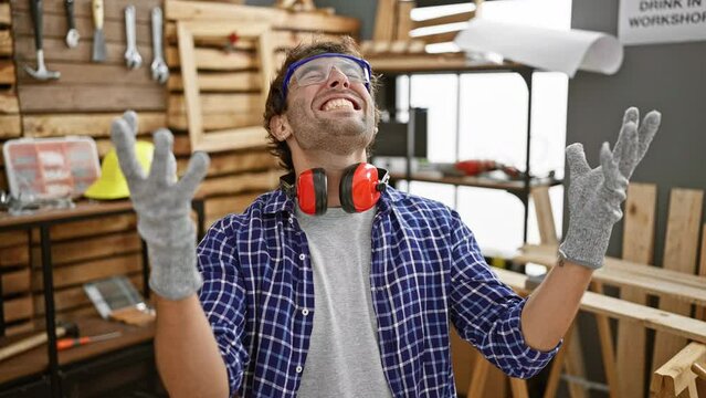 Excited young man, a successful carpenter, goes mad with joy! arms raised, celebrating his big win in carpentry with a wide smile.