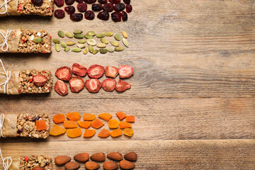 Different tasty granola bars and ingredients on wooden table, flat lay. Space for text