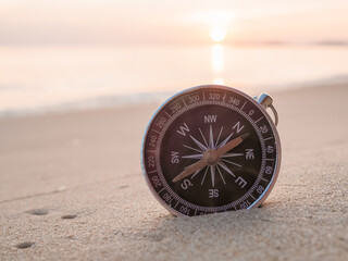Close up compass on the beach with sunlight