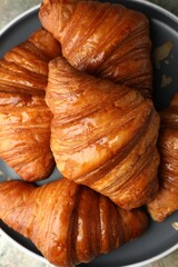 Delicious fresh croissants on grey table, top view