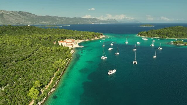 Drone panning shot of Franciscan Monastery Samostan Badija illuminated on a sunny day.