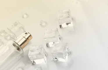 Female perfume bottle, objective photograph of perfume bottle in ice cubes and water. view from above. product photo, concept of freshness and aroma