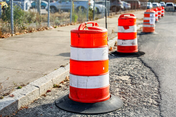 Fototapeta na wymiar orange construction cone on asphalt road with blurred traffic, symbolizing caution and ongoing work in progress