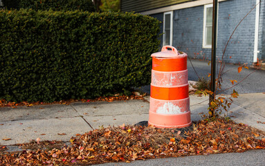 orange construction cone on asphalt road with blurred traffic, symbolizing caution and ongoing work...