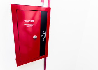 Emergency call box with red beacon at night on city street, offering safety and immediate assistance