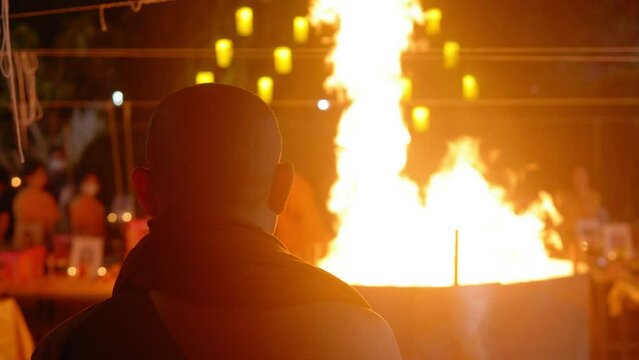 Monk watching Burning Buddhist ancestor's money " Kim cua " and " Gin Cua " Fire