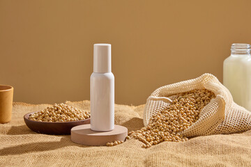 Round podium with a white bottle standing on. Mesh bag and wooden dish containing lots of soybeans...