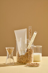 A large beaker containing many soybeans, test tubes and a empty label tube. Front view. Soybeans have vitamins A and E, particularly useful in reducing wrinkles