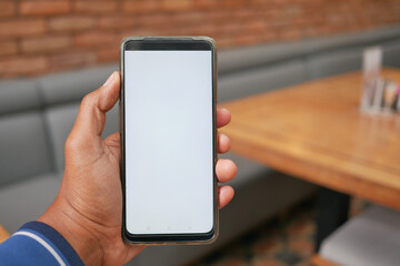 young man hand using smart phone with white screen at cafe 