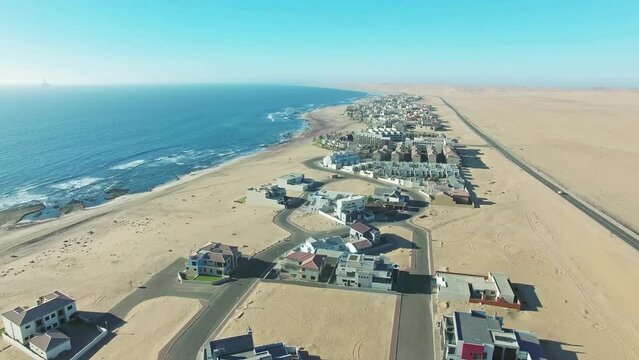 Drone, aerial and desert with beach development in namibia, sand and ocean in africa tourism. Skyline, mapping and navigation for travel on landscape and swakopmund as beautiful holiday destination