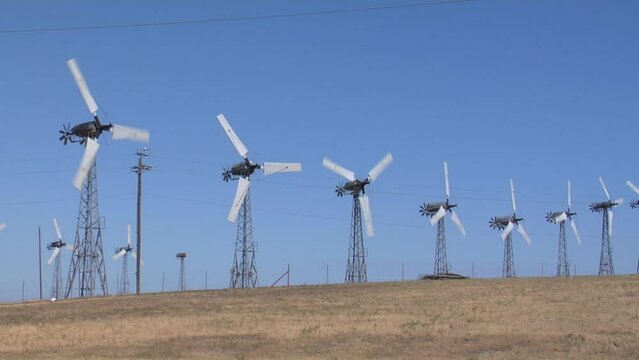 Wind turbines working in Altamont Pass wind farm under blue sky in northern California, USA