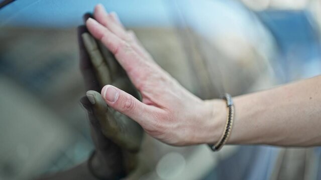 Beautiful couple saying goodbye with hands on window car at street
